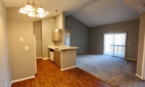A kitchen area with wooden floors and a white refrigerator.