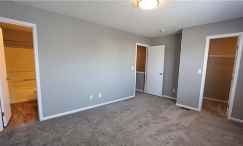 A spacious room with a carpeted floor and a ceiling light.