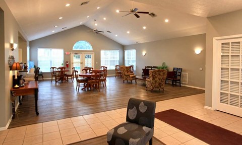 A living room with a fan and chairs.