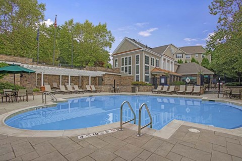 A large outdoor swimming pool with a building in the background.
