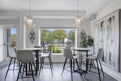A dining room with a table and chairs.