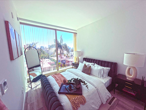 A bedroom with a large bed and a view of the city.