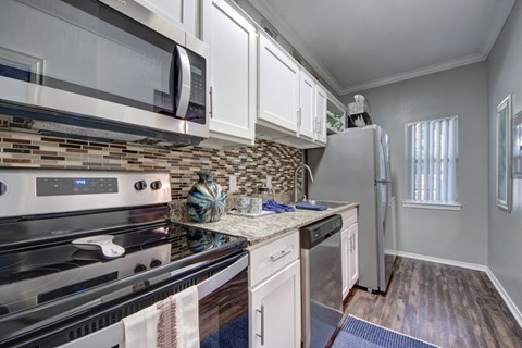 A kitchen with a stove top oven and a microwave above it.
