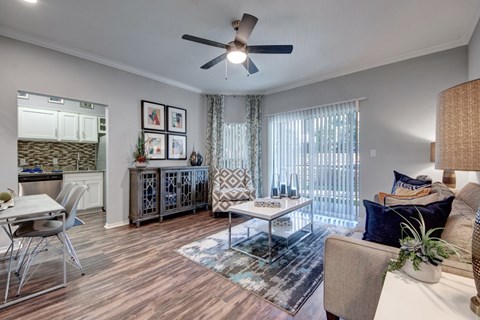 A living room with a white couch, a coffee table, and a ceiling fan.