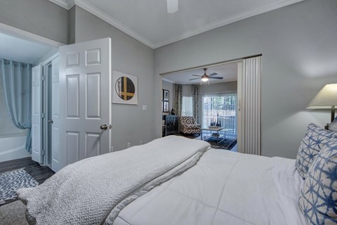 A bedroom with a large bed and a ceiling fan.