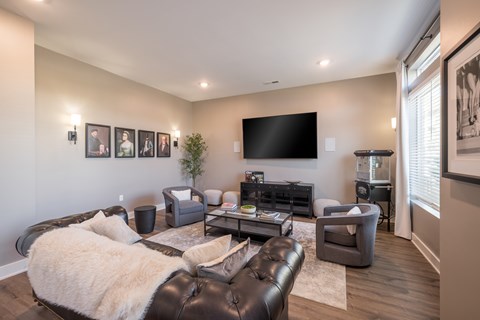 A living room with a large couch and a flat screen TV mounted on the wall.