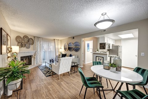 A dining room with a white table and green chairs.
