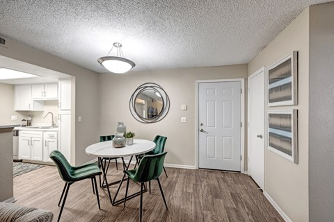 A dining room with a round table and chairs.