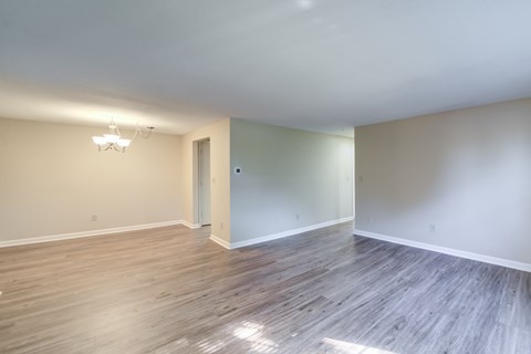 A room with wooden flooring and a chandelier.