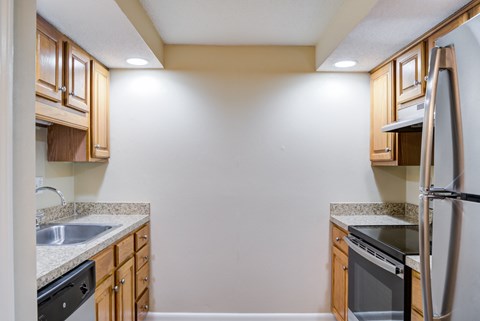 A kitchen with wooden cabinets and a stainless steel refrigerator.