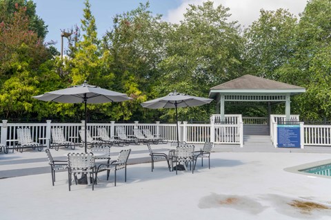 A poolside area with chairs and umbrellas overlooking a pool.