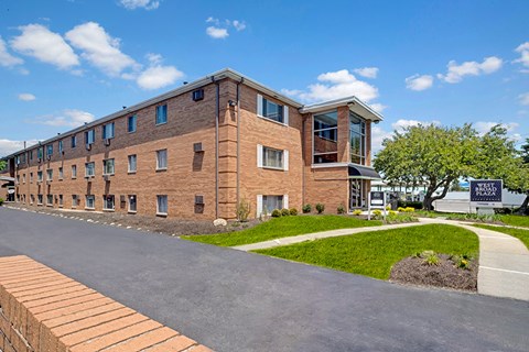 A long brick building with a sign that says "Next" on it.