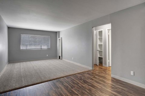 A room with a grey wall and a wooden floor.
