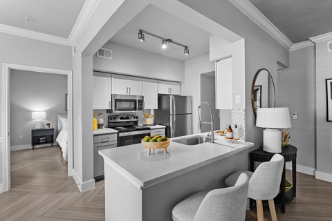 A modern kitchen with a large island and a dining area.