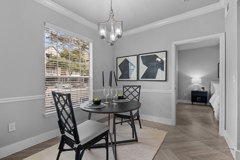A dining room with a table and chairs.