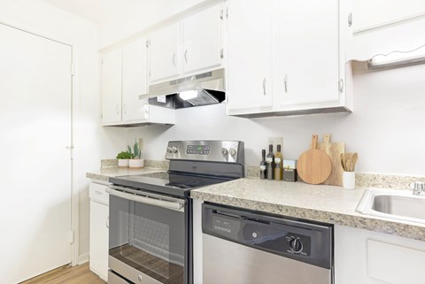 A modern kitchen with white cabinets and stainless steel appliances.
