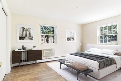 A bedroom with a large bed and a window with blinds.