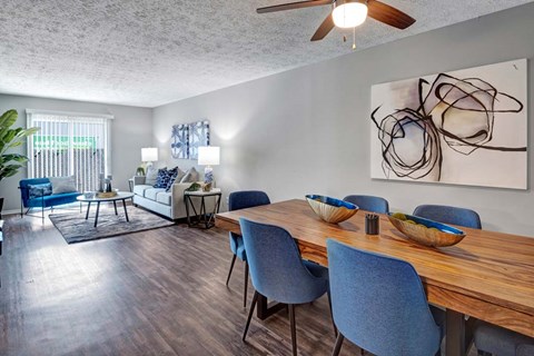 A modern dining room with a wooden table and blue chairs.