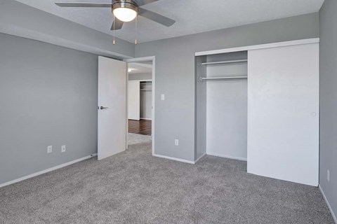 A room with a ceiling fan and carpeted floor.