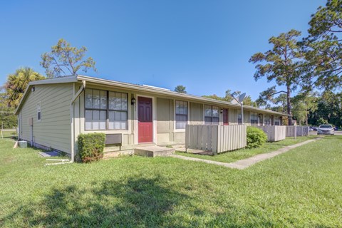 A row of houses with green lawns in front.