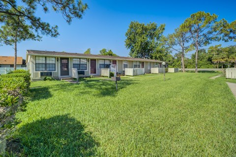 A house with a green lawn in front of it.
