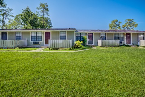 A row of houses with green lawns in front.