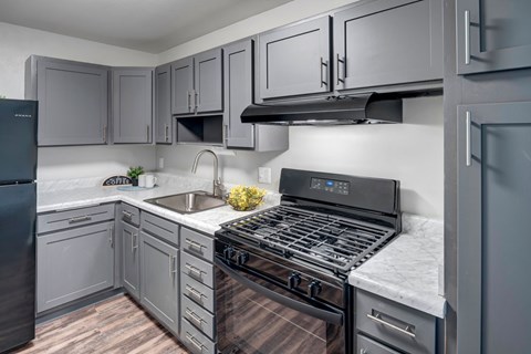A modern kitchen with a black stove top oven.