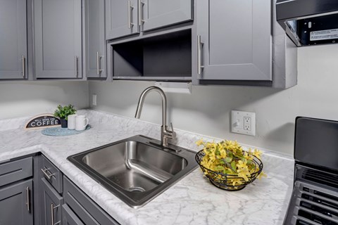A kitchen with a sink and a bowl of flowers.