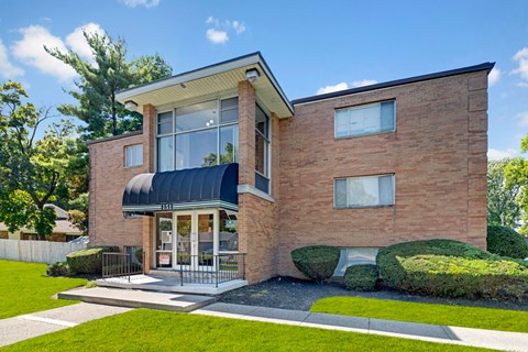 A modern brick house with a black awning and a glass door.