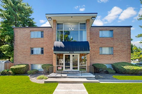 A modern brick building with a black awning and a glass entrance.