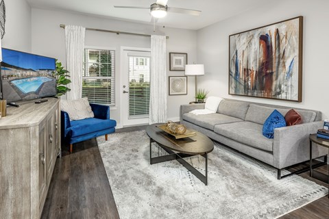 A living room with a blue chair and a grey couch.