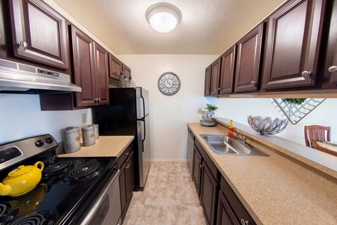 A kitchen with brown cabinets and a black stove top.