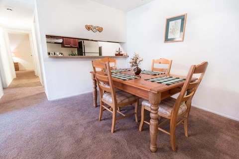A dining room with a wooden table and chairs.