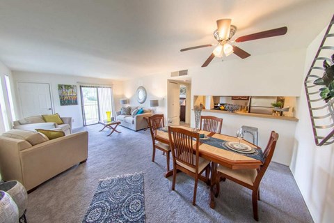 A living room with a dining table set up with chairs around it.