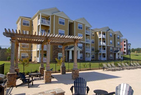 A large building with a patio and chairs in front.