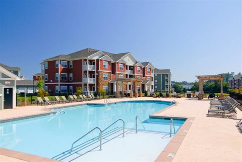 A large swimming pool in front of apartment buildings.