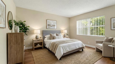 A bedroom with a large bed and a chair.