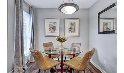 A dining room with a glass table and chairs.
