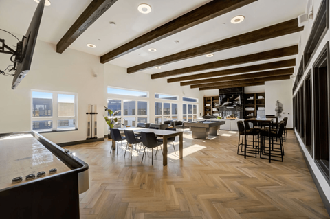 A modern kitchen with a pool table and a dining table.