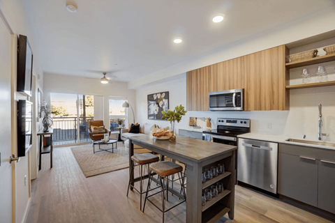 A modern kitchen with a wooden bar and stools.