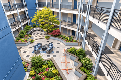 A courtyard with a fountain and a tree in the middle of it.