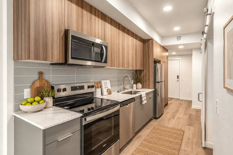 A modern kitchen with wooden cabinets and stainless steel appliances.