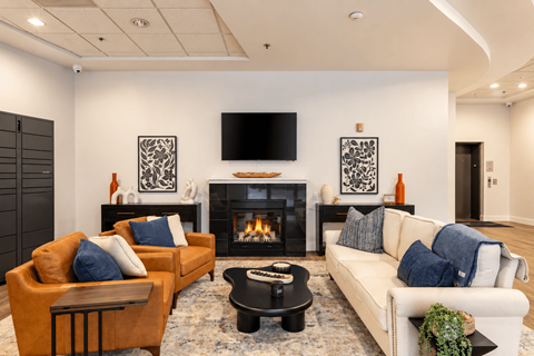 A living room with a fireplace and a television on the wall.
