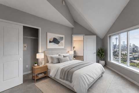 A bedroom with a large bed and a view of the city.