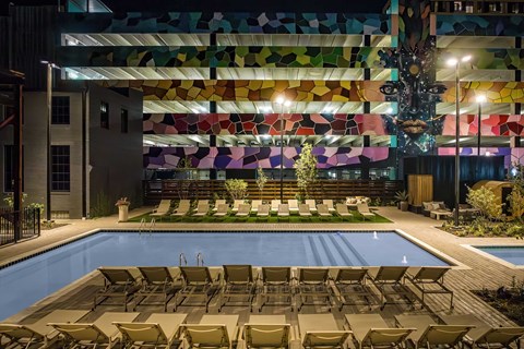 A pool area with a colorful mosaic wall and a Christmas tree.