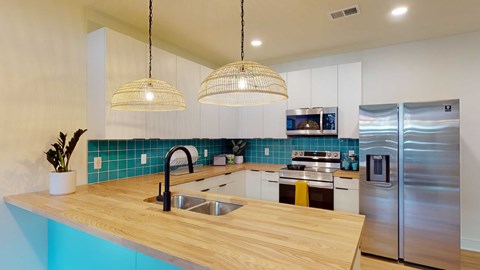 A kitchen with a wooden counter top and stainless steel appliances.
