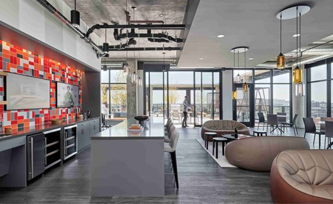 A modern kitchen with a long counter and a person standing at the end.