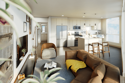 A modern living room with a brown couch and a kitchen in the background.