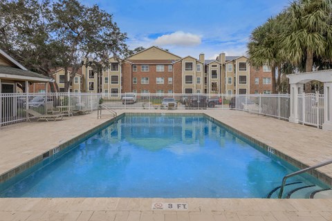 A swimming pool in front of apartment buildings.