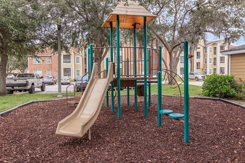 A playground with a slide and a wooden platform.
